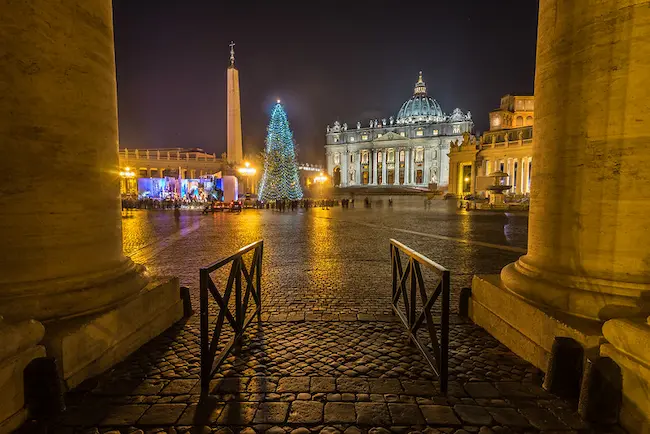 St. Peter’s Basilica glowing under warm lights, with festive decorations enhancing the holiday atmosphere.