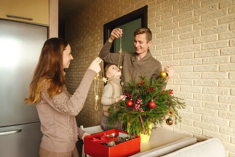 Family joyfully decorating their home with string lights, fostering creativity and meaningful connections through shared holiday activities.
