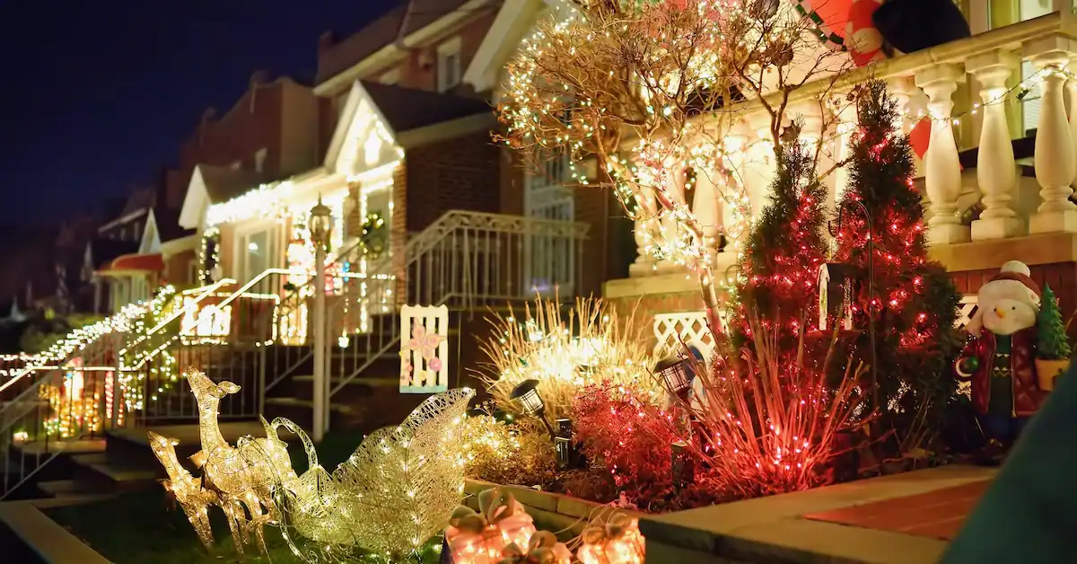 A street decorated by glowing holiday lights and decor.